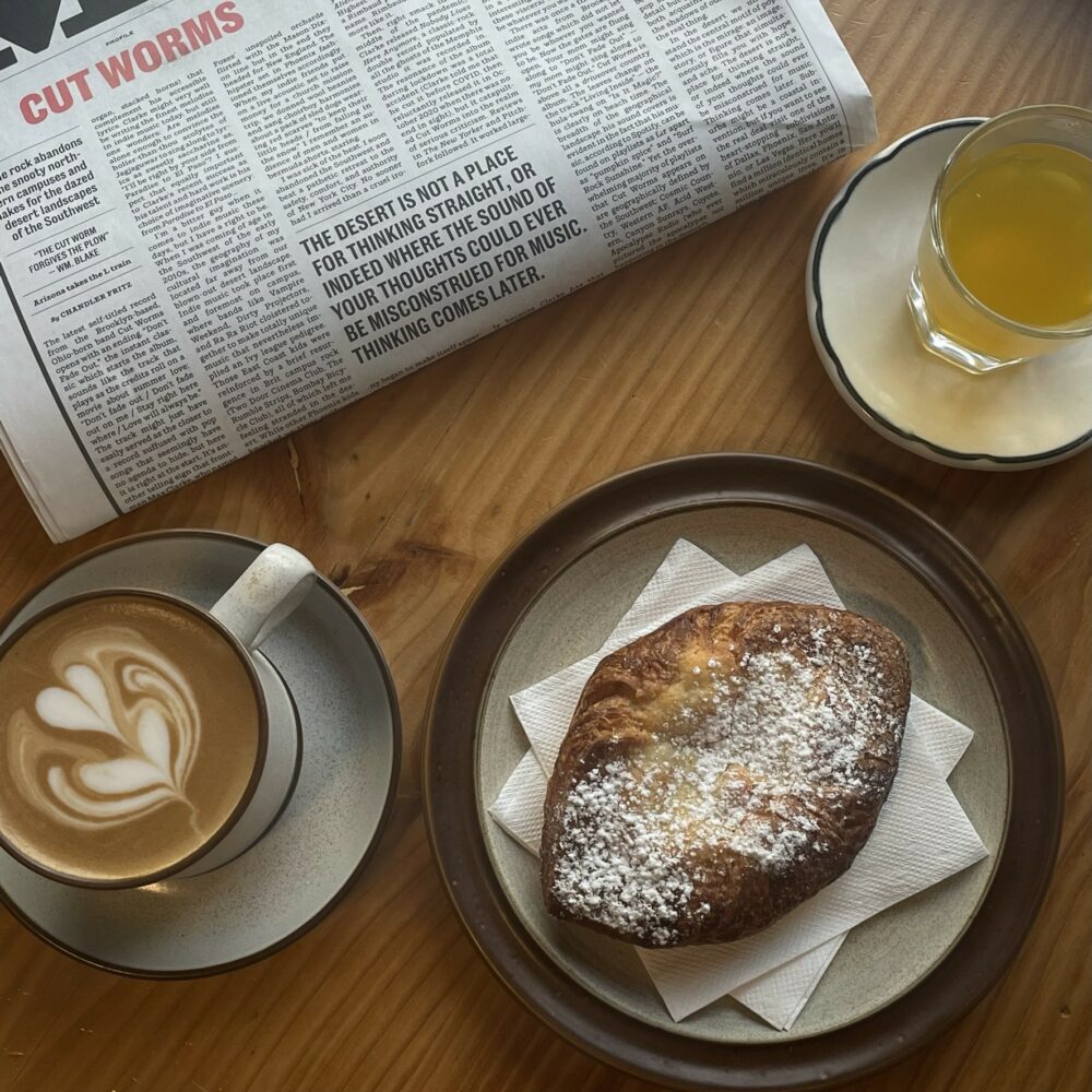Coffee, pastry and newspaper image in cafe.