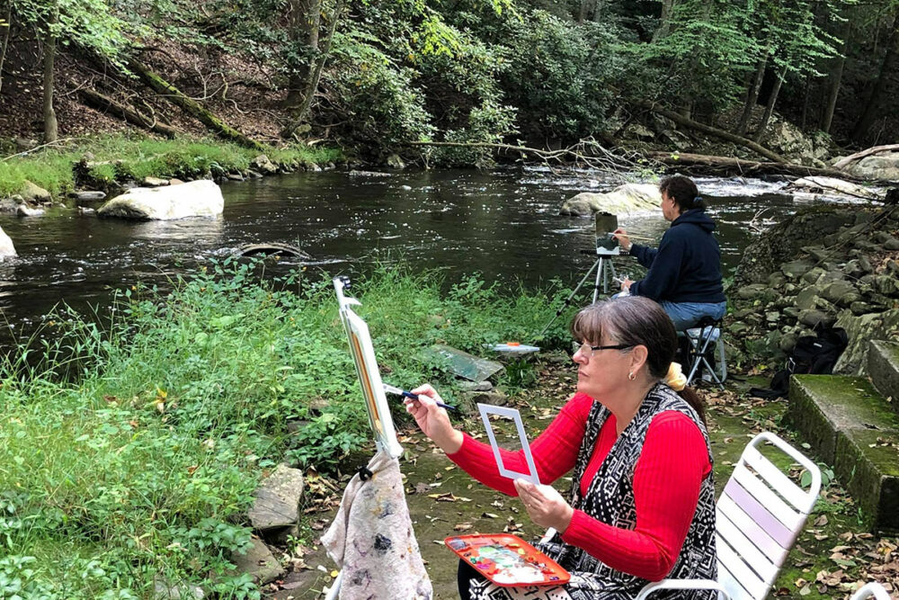 two painters along the river