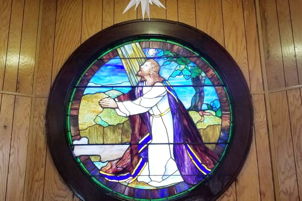 stained glass window of Jesus praying